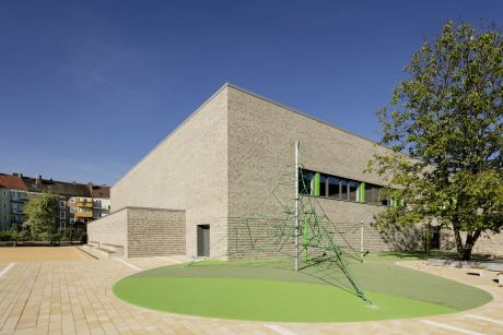 Sporthalle außen: Großzügige Freiflächen bieten Platz zum Toben und vermitteln durch ihre interne Lage gleichzeitig Geborgenheit und Sicherheit.