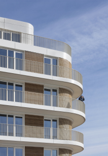 Horizontale Gliederung: umlaufende, helle Balkonkragplatten mit Stabgeländern und Lärchenholzlamellen-Elementen in der Fensterebene, Foto © Werner Huthmacher, Berlin